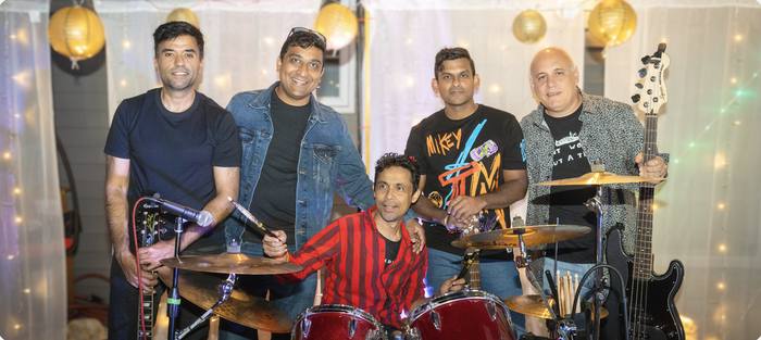 Band under paper lanterns at a house party